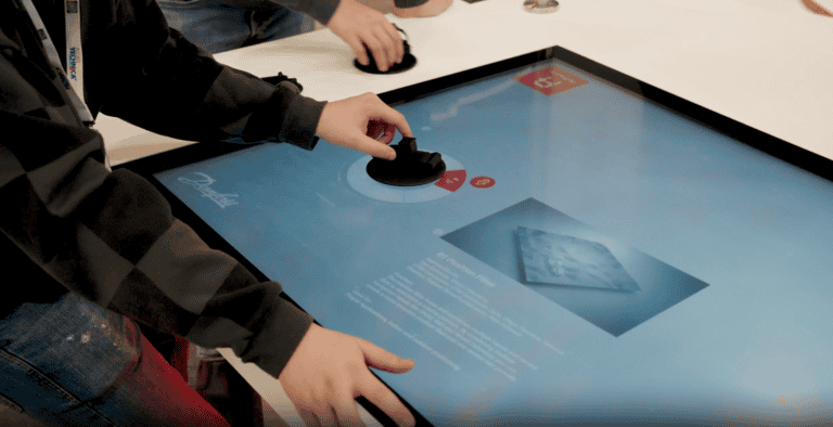 An interactive digital table demonstrates experiential marketing agency SPIRO’s creative branding and trade show design