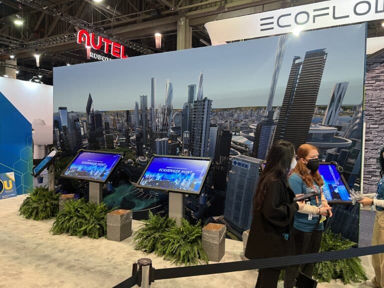 Large monitors placed in front of a digitally projected cityscape demonstrate the creative branding and exhibition booth design of experiential marketing company SPIRO