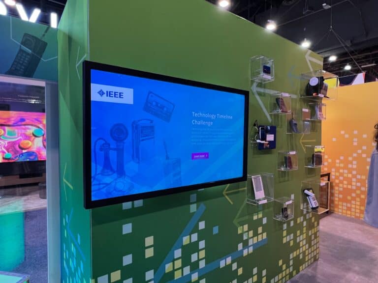 An interactive booth displays various handheld devices, showcasing experiential marketing agency SPIRO’s trade show booth design